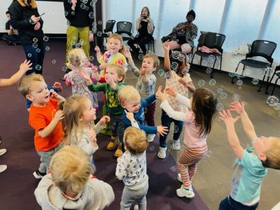 Children play with bubbles in the library.