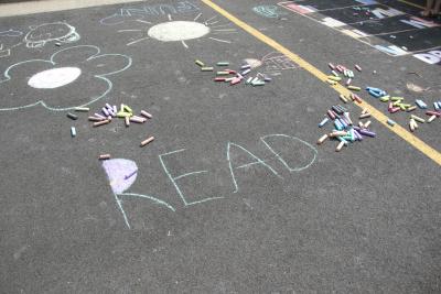 Chalk on a sidewalk says "Read".