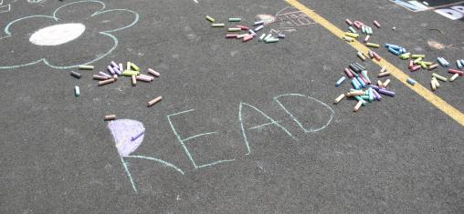 Chalk on a sidewalk says "Read".