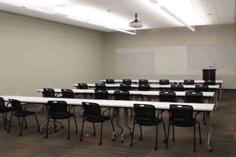 one half of a large meeting room space set up with tables and chairs