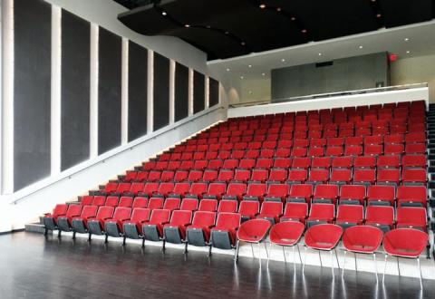 View of Whipple Auditorium from the front stage showing rows of red seats