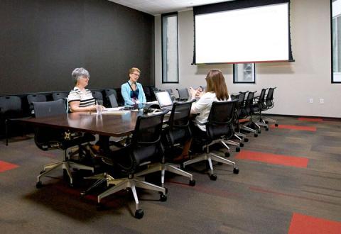 Small Conference Room with three people around large board table